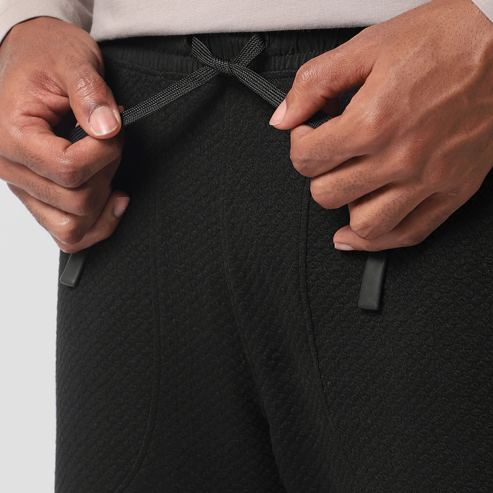Roam Jogger Black close up of model tying drawstring