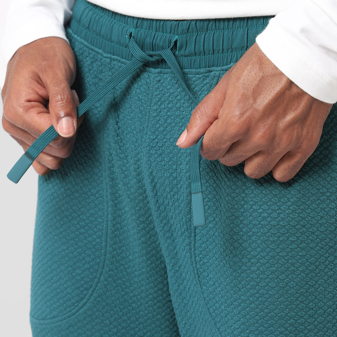 Roam Jogger Dark Teal close up of model tying drawstring
