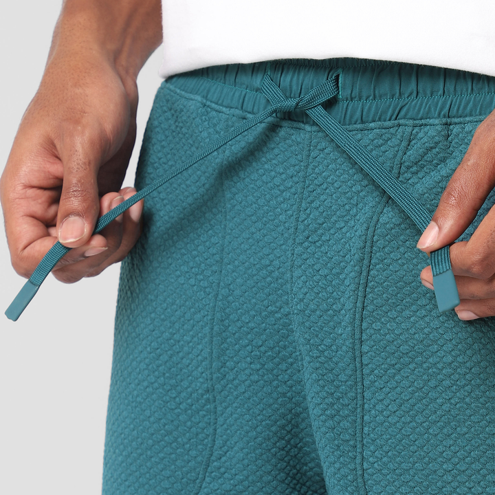 Roam Short 5.5" Dark Teal close up of model tying drawstring